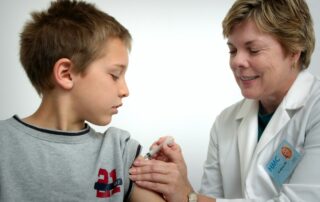 woman inject boy on arm