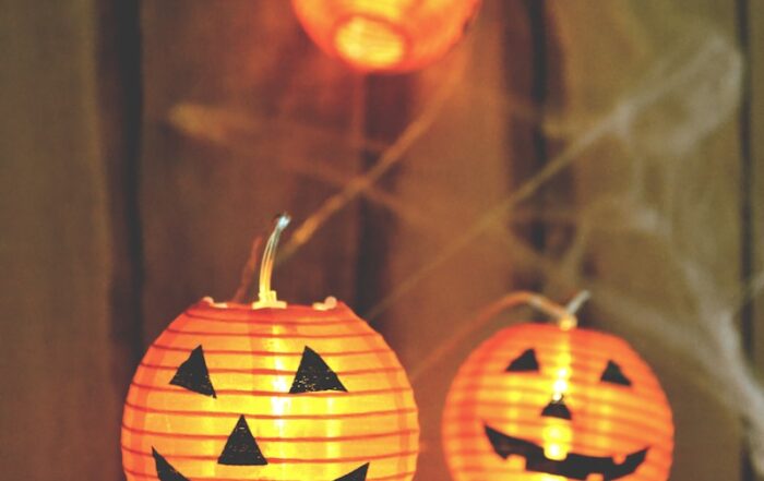 three jack-o-lantern lamps on beige wooden board