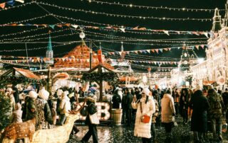 a crowd of people walking around a christmas market